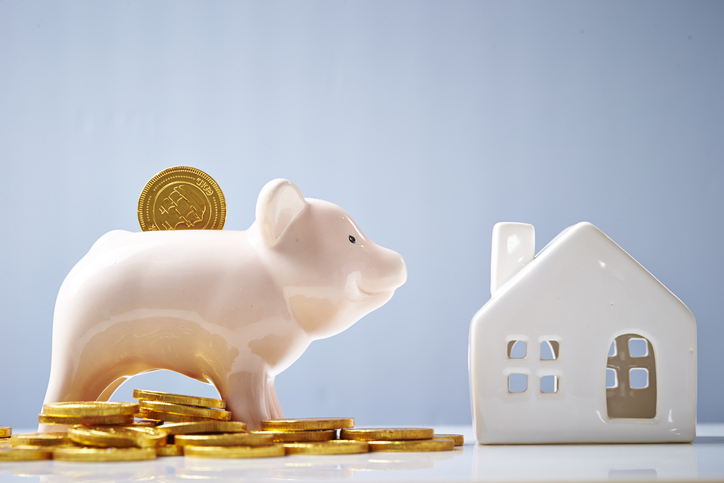 Coins with piggy bank and house model