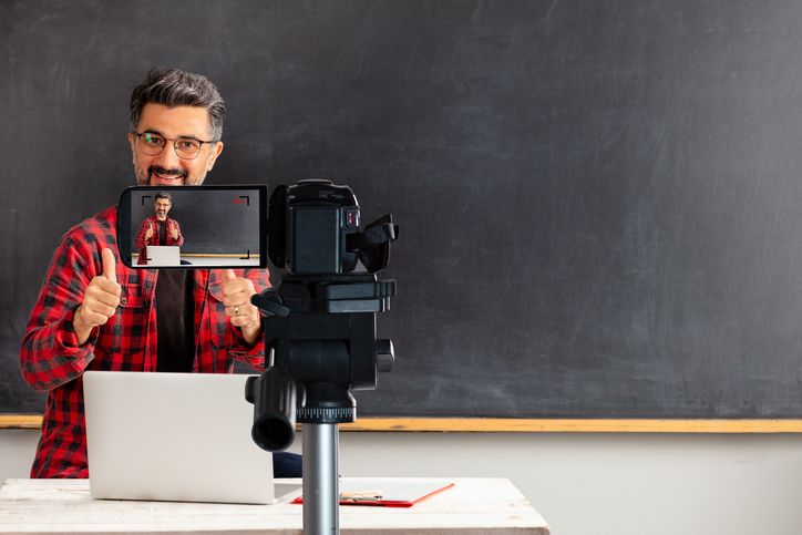 Adult man teacher is filming movie for online education.