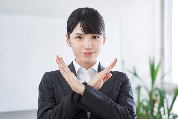 Japanese women in business who give the "no" sign at the office