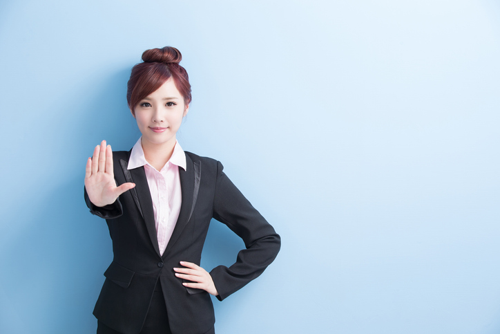 business woman do a stop gesture with isolated on blue background, asian