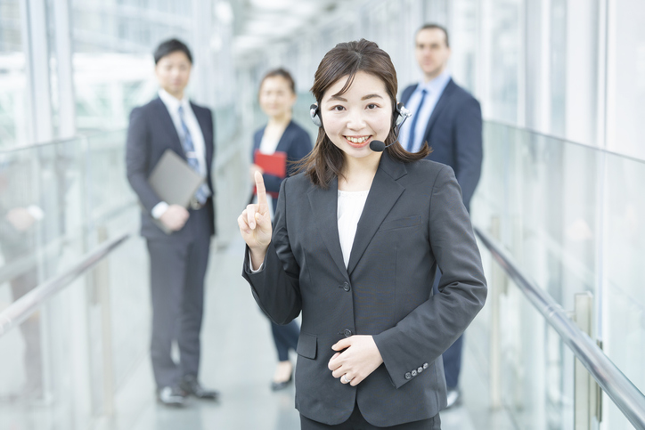 Business woman wearing a headset and her business team